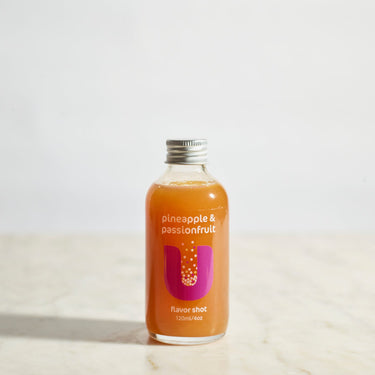 Bottle of pineapple and passionfruit juice on a light background
