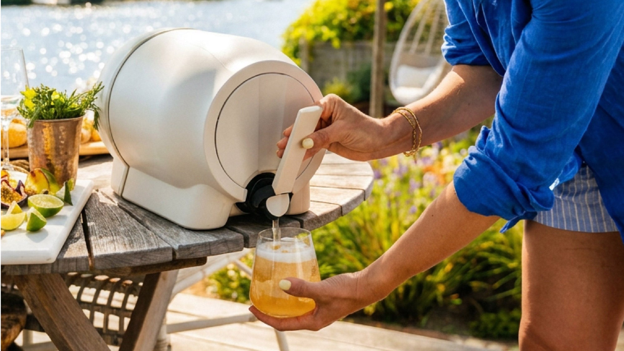 bruusta kombucha brewing system, a person pouring from the tap outside in summer time
