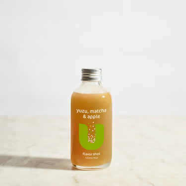 Bottle of yuzu, matcha, and apple flavor shot on a light background