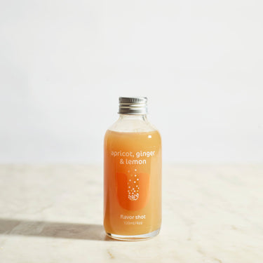 Bottle of apricot ginger lemon flavor shot on a light background