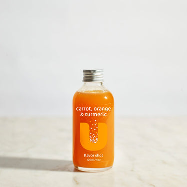 Bottle of carrot, orange, and turmeric flavorshot on a light background